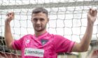 Dunfermline Athletic loan signing Mason Munn stands with his fingers through the goal nets.