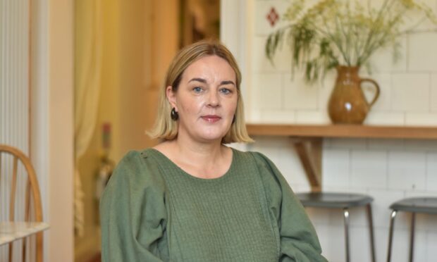 Laura Wilson, sitting in The Mercat in Culross