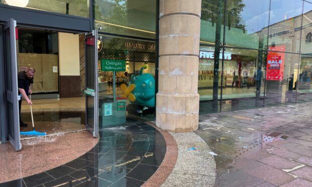 Staff mopping the flooded floor. Image: Lucy Scarlett/DC Thomson