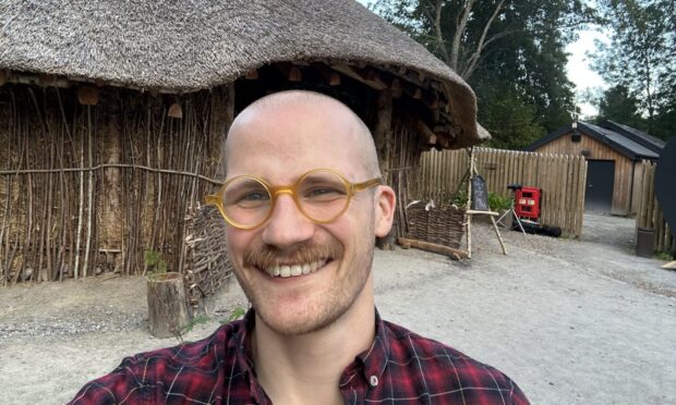 Jacob Smith posing in front of a roundhouse.
