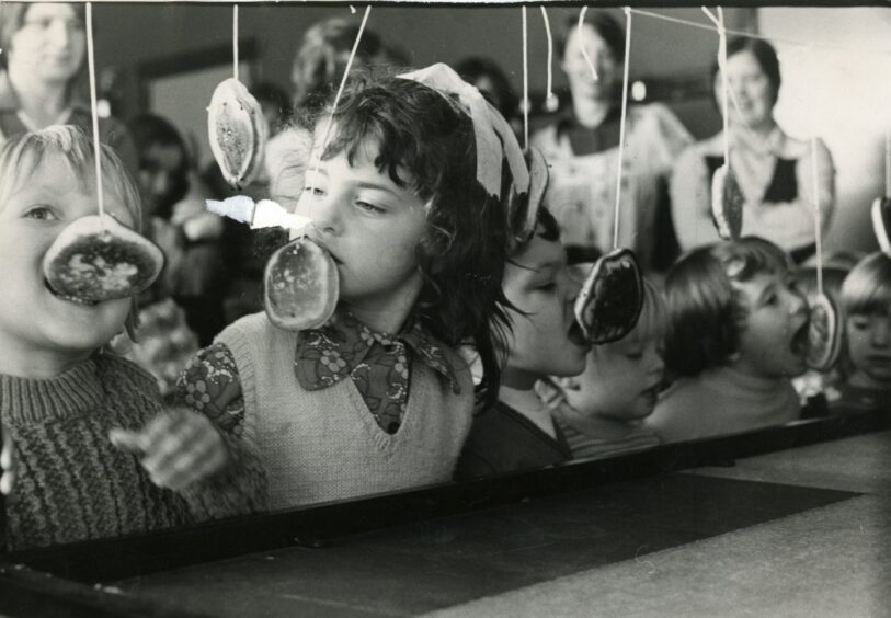 Eating treacle scones at Ardler Community Centre playgroup's Halloween party in 1975.