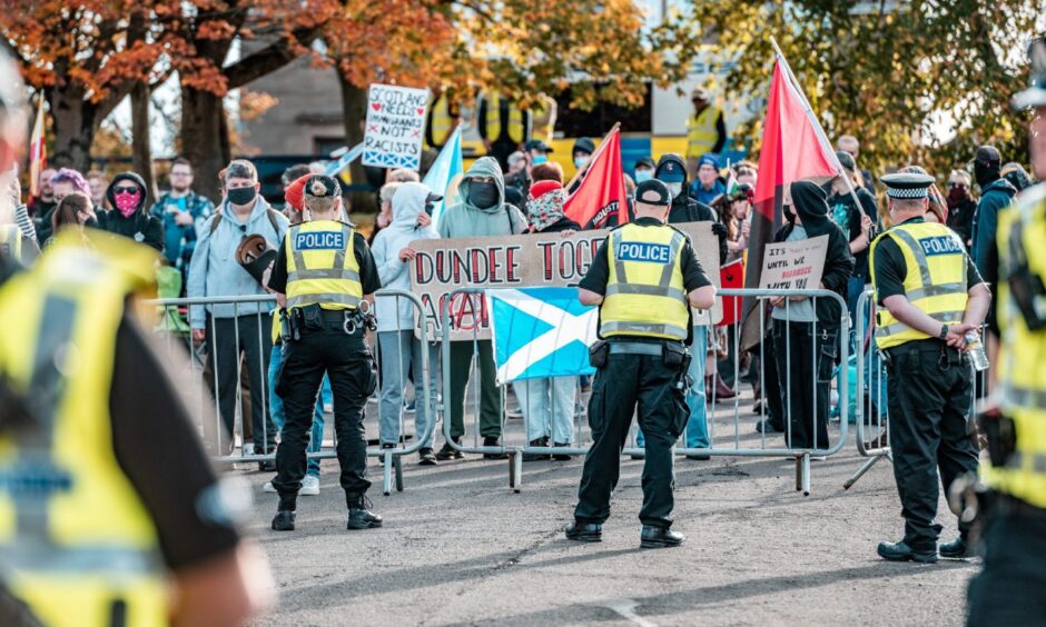 Police in front of those who gathered to oppose the latest anti-immigration demonstration, holding messages of welcome.