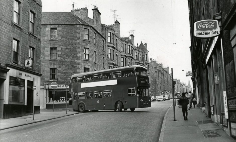 A bus turns into Albert Street, Dundee, as people walk on the pavement