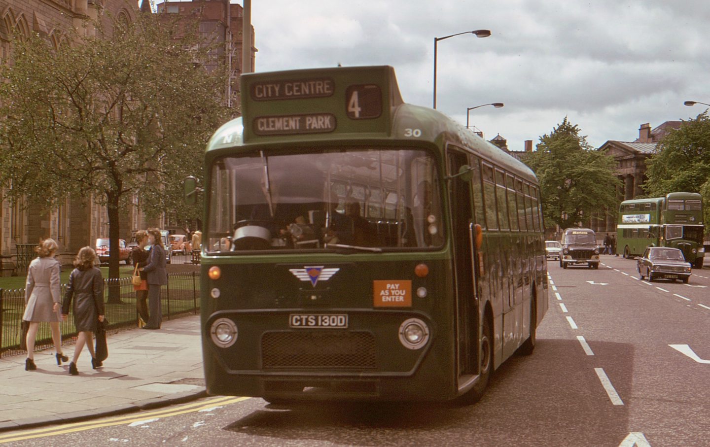 A green bus next to Albert Institute in Dundee.
