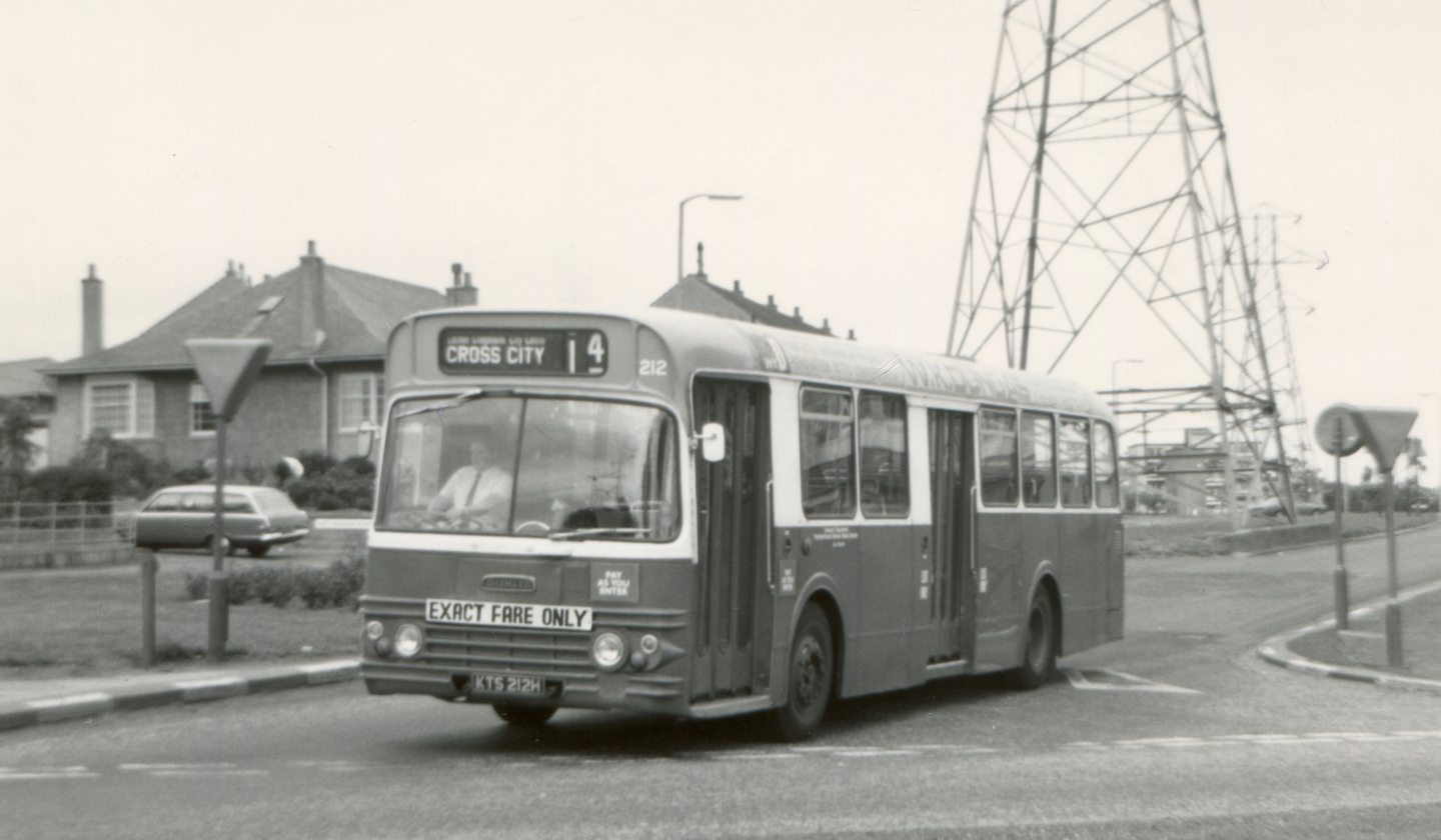 A bus in Dundee passing electric pylons.