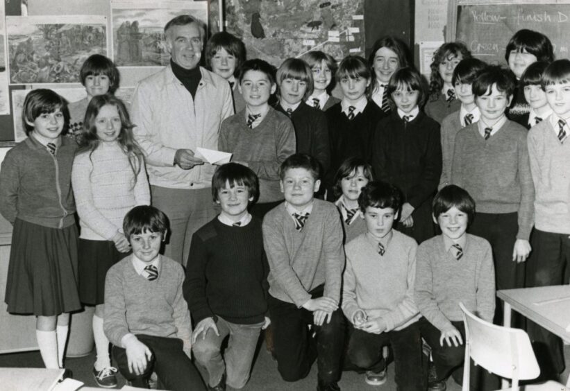 Broughty Ferry lifeboat coxswain John Jack receives a cheque from primary pupils in Whifield. 
