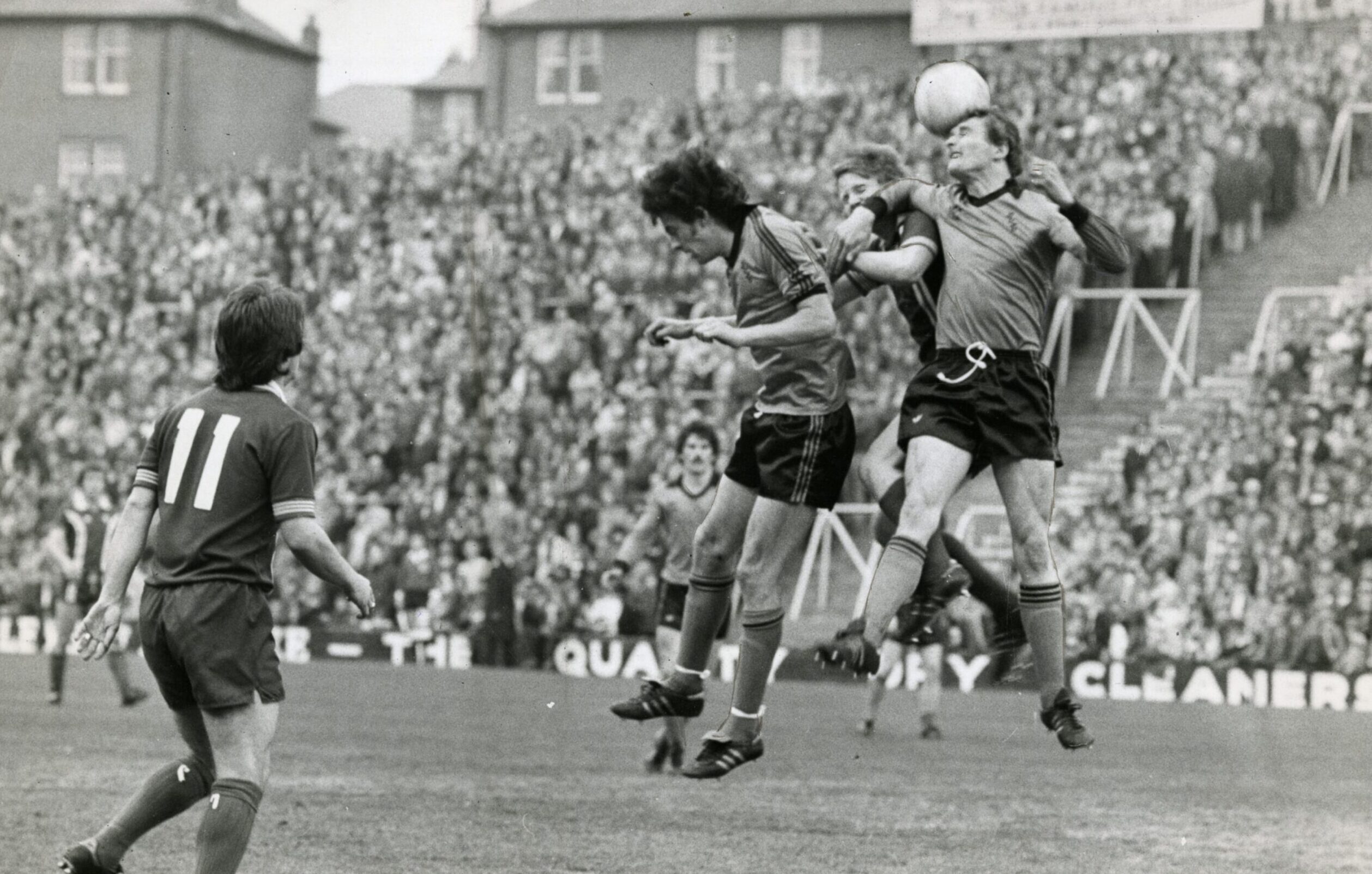 Paul Hegarty rises high to win a header in a Forfarshire Cup game against Dundee. Part of the 12,170 crowd is in the background.