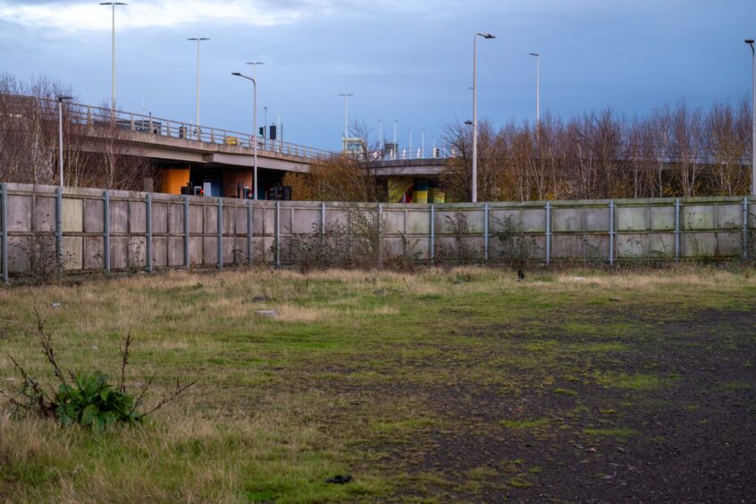 View through hole in gate of empty plot on Earl Grey Place East, Dundee.