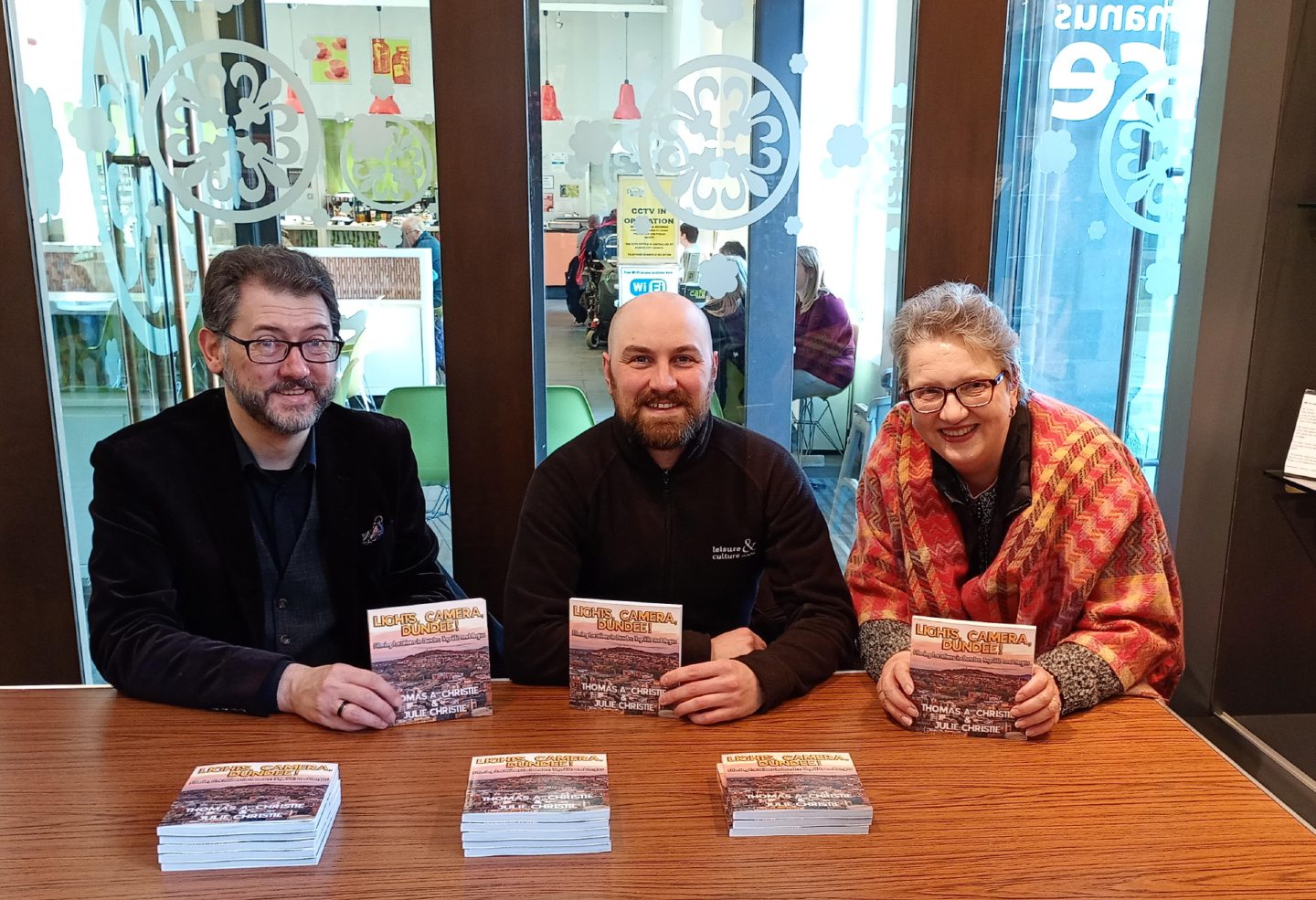 A line up of people with a book.