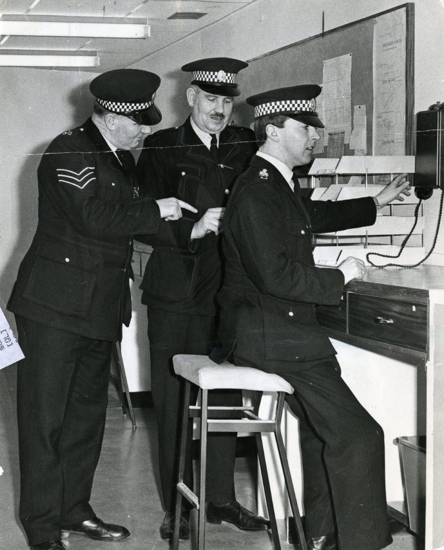 Three police officers at a desk.