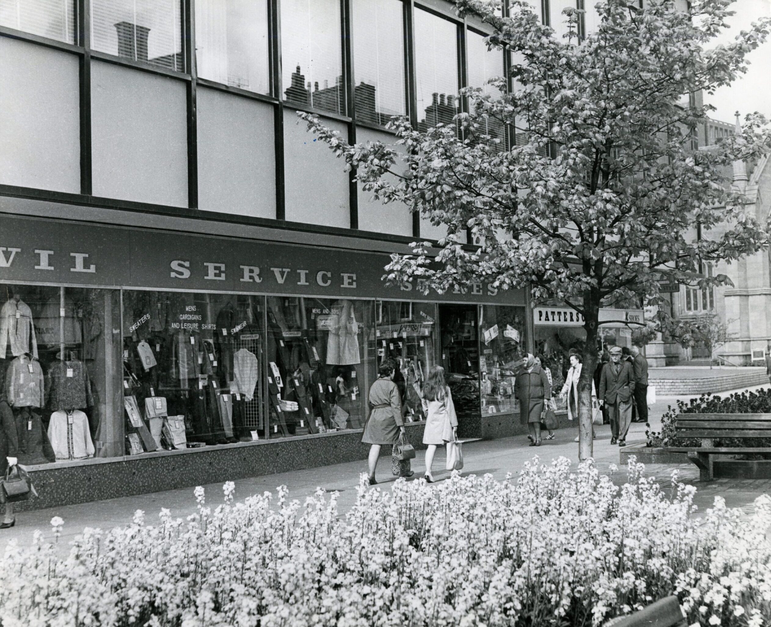 People walk past a shoe shop.