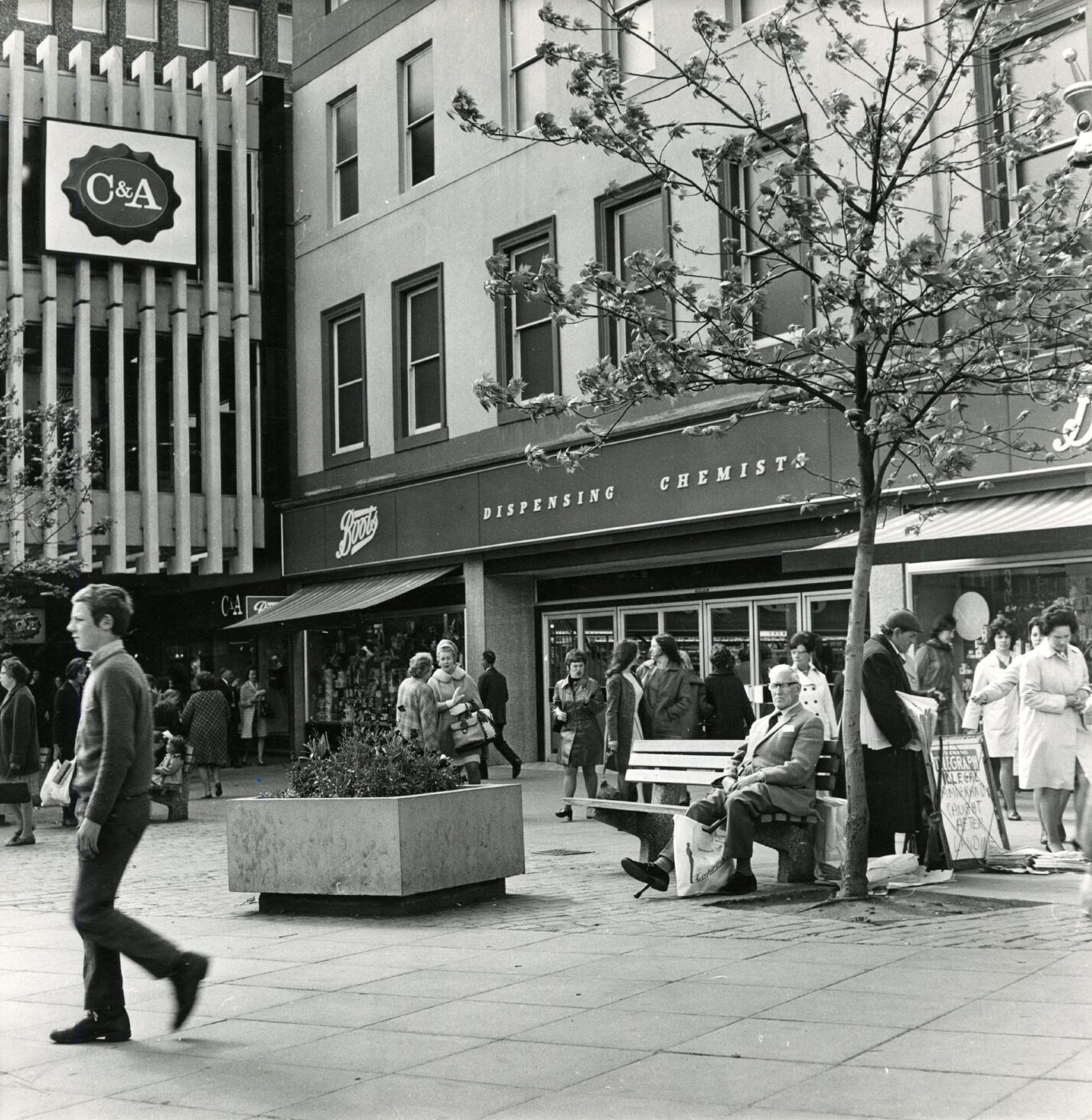 A square outside the Overgate in Dundee with people milling.