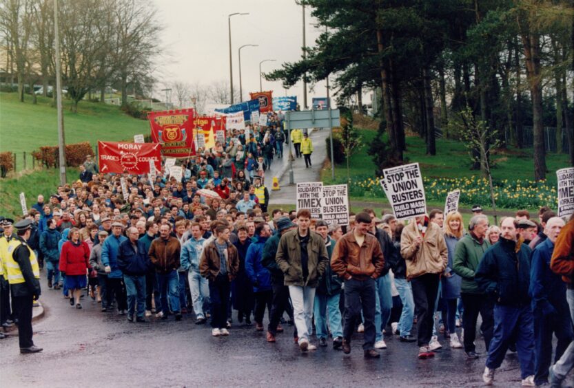 Strikers, some carrying banners and placards, on a protest march against the Timex closure.