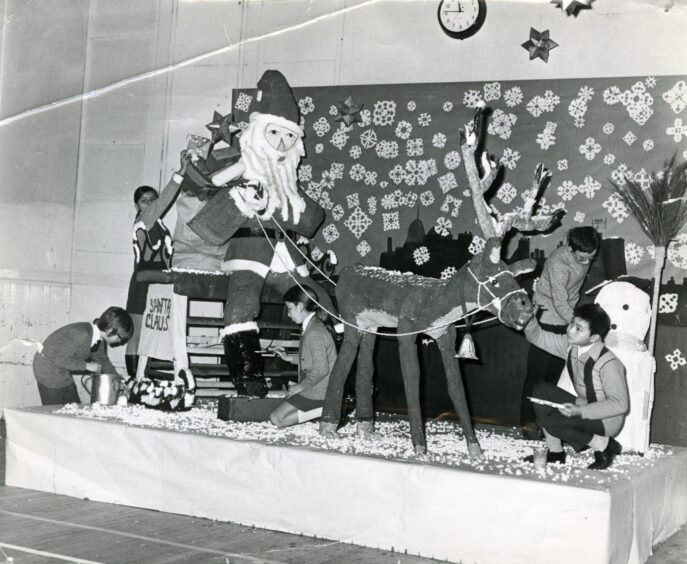 pupils decorating a model Santa with a sleigh and reindeer