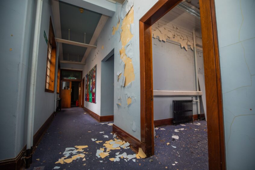 Blue walls with plaster falling on grubby carpet