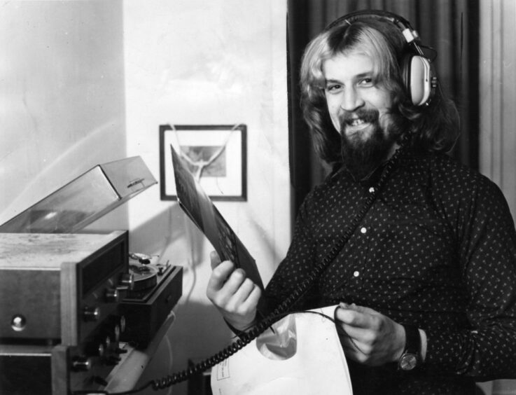 a smiling Connolly listening to one of his records in 1974.