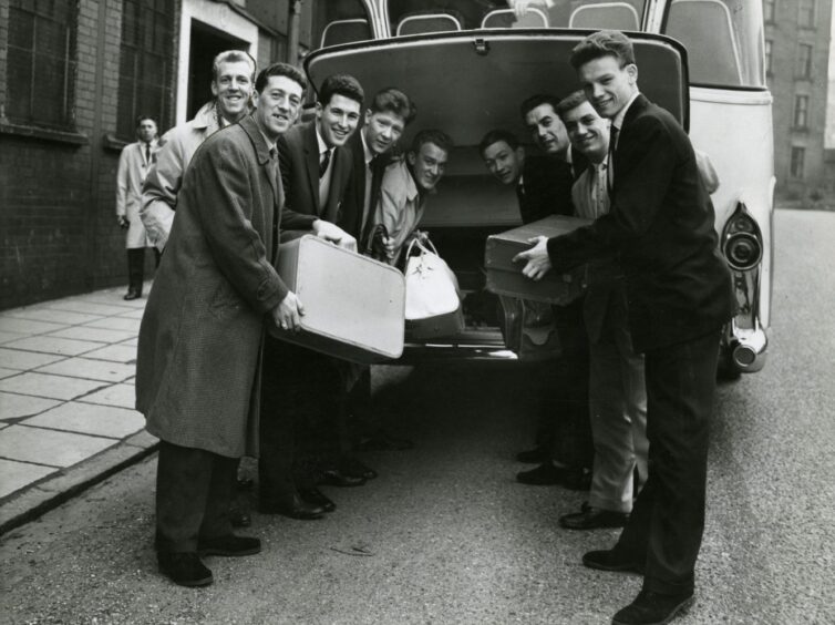 Players loading luggage on to a bus outside Dens Park.