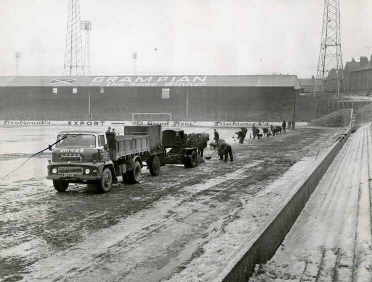 Vehicles and workers on the pitch in 1963.