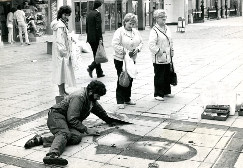 Gerry Commissaris works on a pavement portrait of the Mona Lisa.