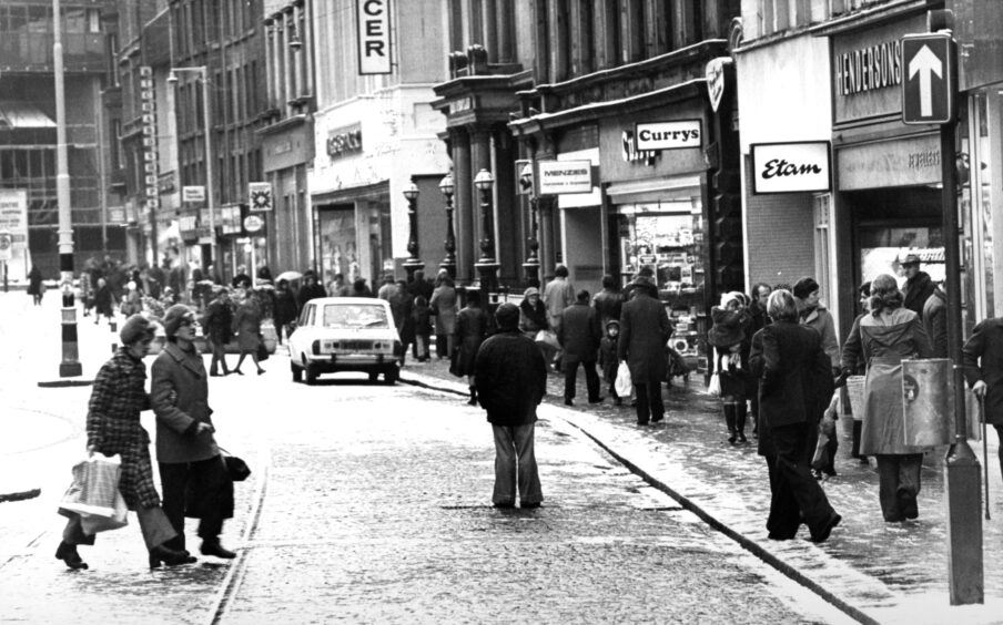 people walking in a busy scene in the Murraygate.