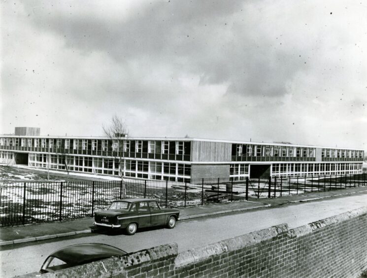 The new school building for Lawside Academy in Dundee with two cars outside.