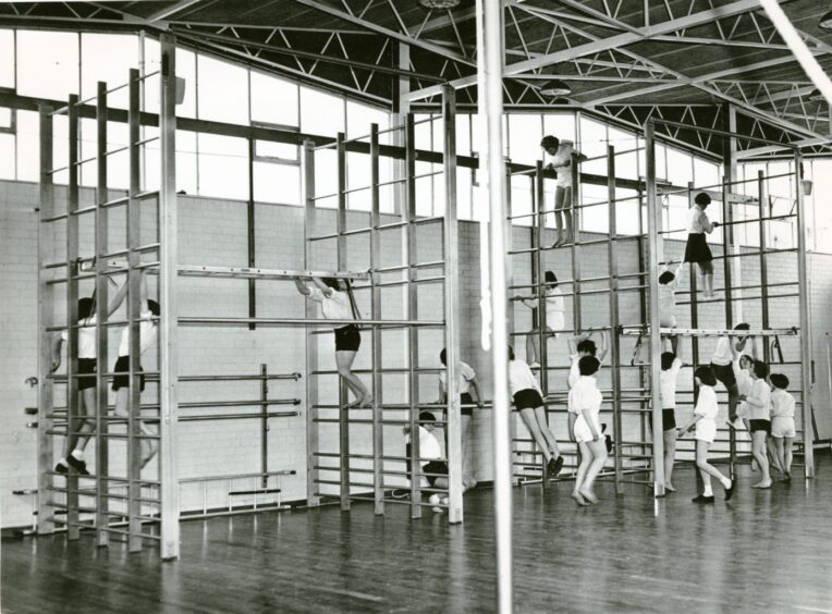 Girls on the climbing frame while taking a gym class in May 1966. 