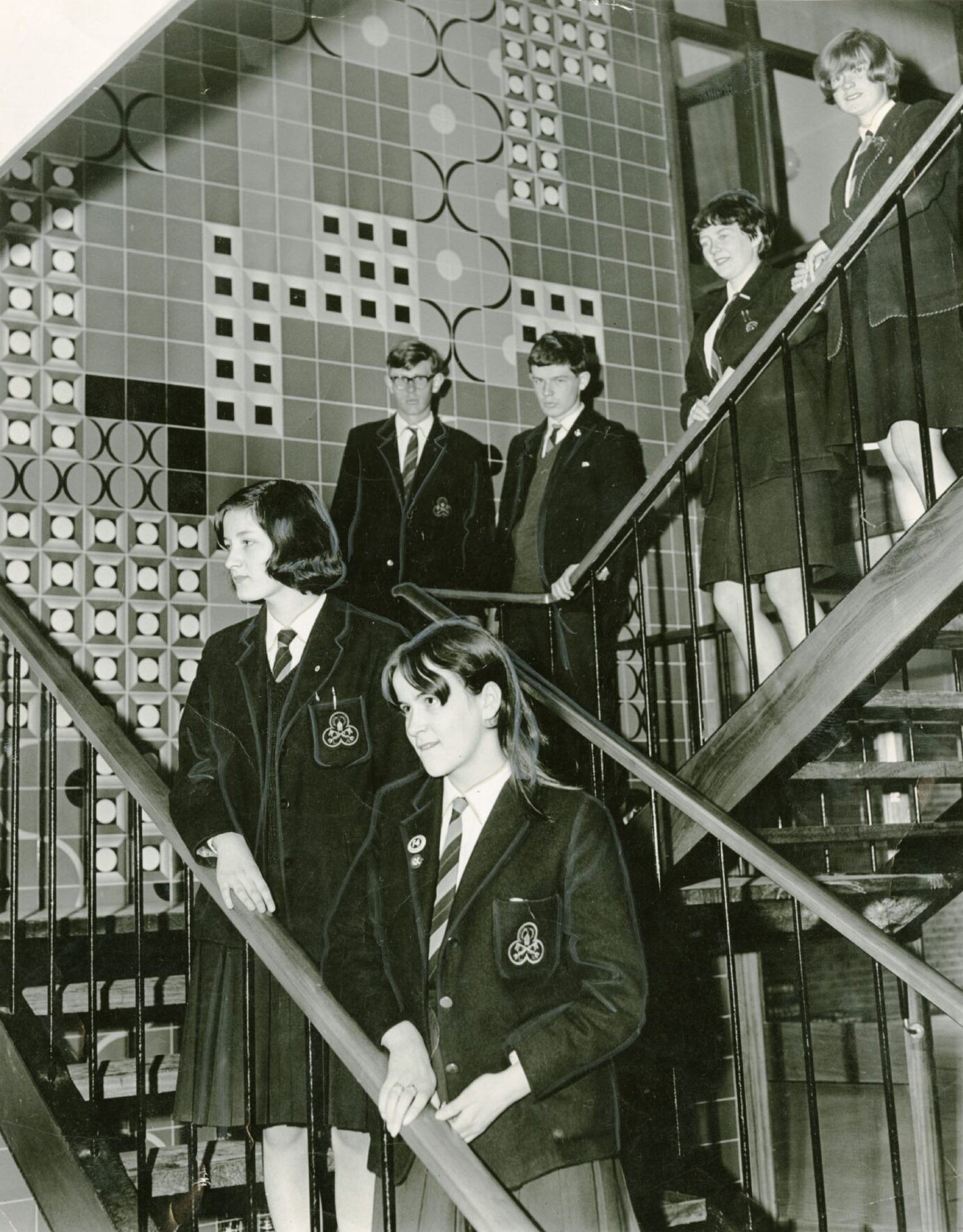 Pupils at Lawside Academy in Dundee stand beside murals on a staircase