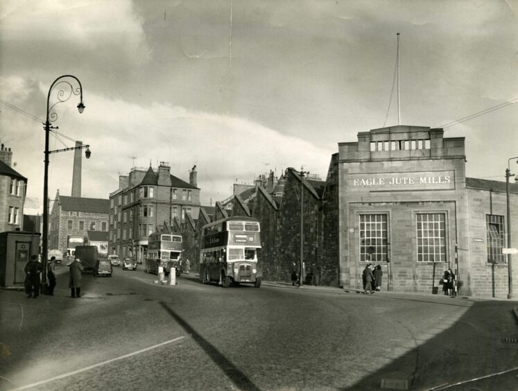 A busy road outside the Eagle Mills site in Dundee, with a bus going by.