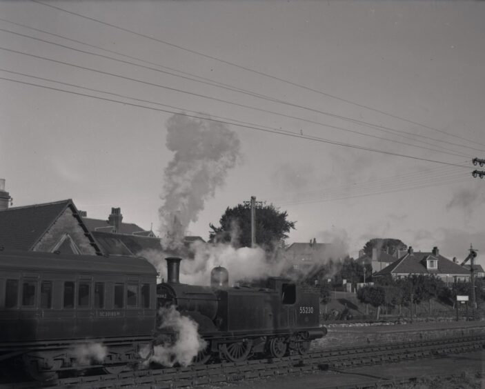 A steam train puffs steam and smoke at Barnhill.