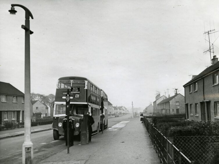 Three Dundee Corporation Transport staff stand beside a No. 28 bus bound for Charleston at Balunie Avenue in January 1961.