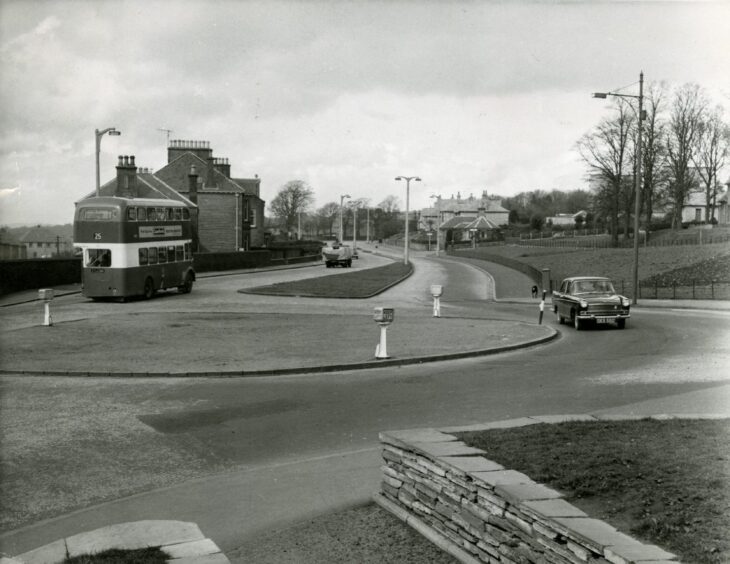 A Dundee Corporation bus and car on a roundabout