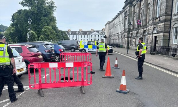 Police officers in Rose Terrace, with a barrier cordoning off part of the street
