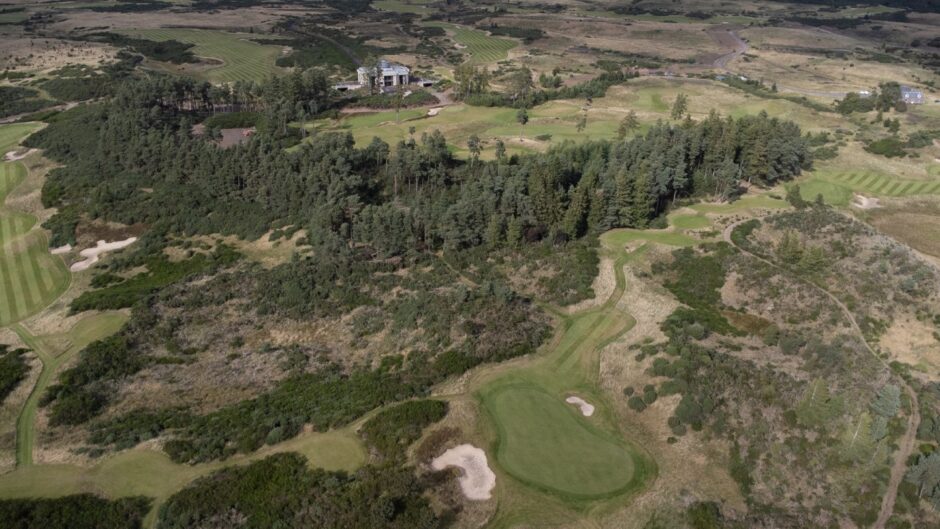 One of the green's on the mysterious course, with the clubhouse overlooking in the background