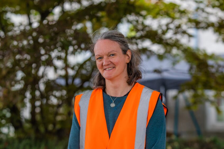 Lucy Dean in high vis vest in front of tree