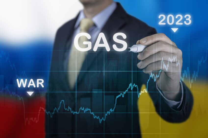 A graphic showing a man writing on a screen 'gas' 'war' and '2023' to represent climate change and energy crisis