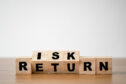wooden blocks spelling 'risk' and 'return'