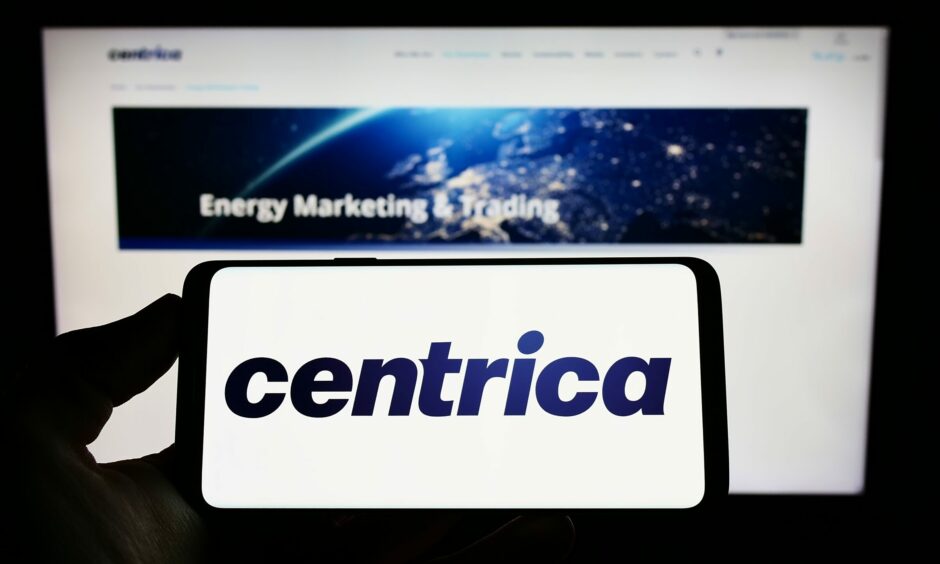 Hand holding a phone that reads "Centrica" on screen.