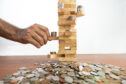 Coins being balanced on Jenga game blocks.