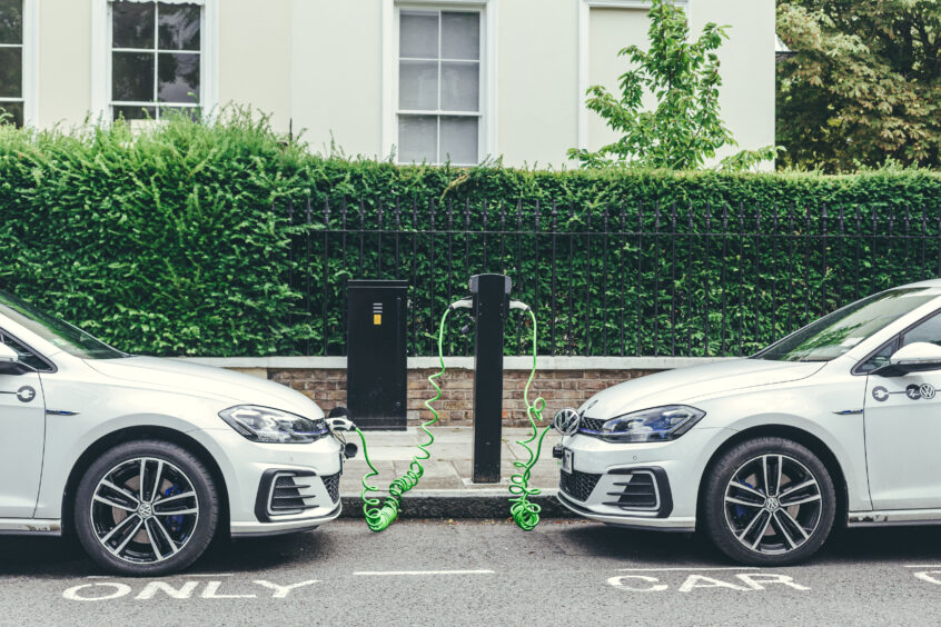 Two electric cars parked in  a London street.