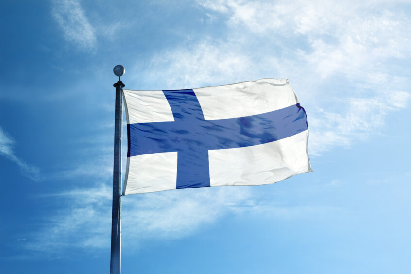 Finland's flag flies against a blue sky.
