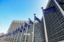 European union flags on in front of the EU Parliament.