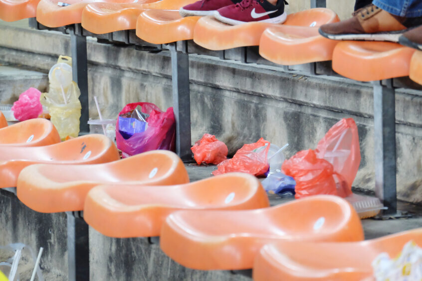 Bags of litter left under the seats of a sporting event.