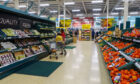 Shoppers browse the aisles of a Tesco supermarket.
