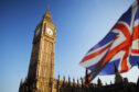 UK flag flies infront of Big Ben clock tower.