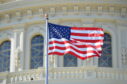 US flag flies infront of the Capitol building.