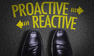 Pair of smart business shoes at a crossroads between "proactive" and "reactive".