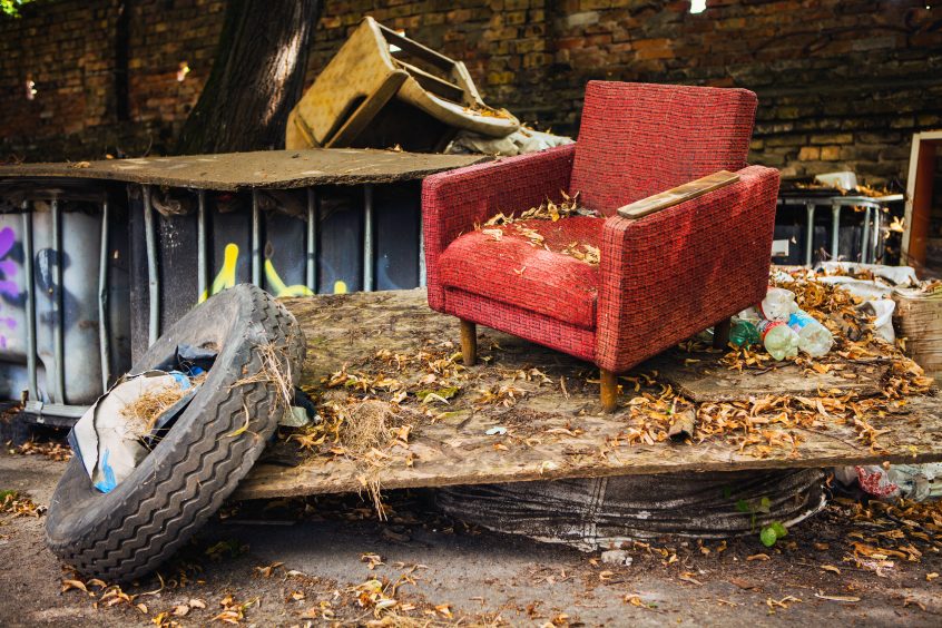 A luxurious armchair tops off a pile of discarded waste.
