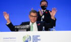 Alok Sharma raises his hands as an agreement is reached at Cop26