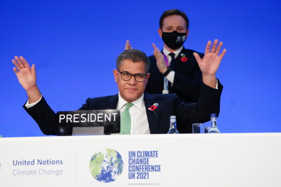 Alok Sharma raises his hands as an agreement is reached at Cop26