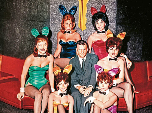 Playboy dated circa 1960 of their founder Hugh Hefner with some Playboy bunnies.